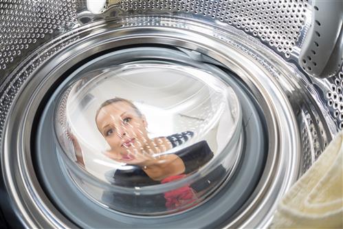 Woman's reflection in a laundry machine